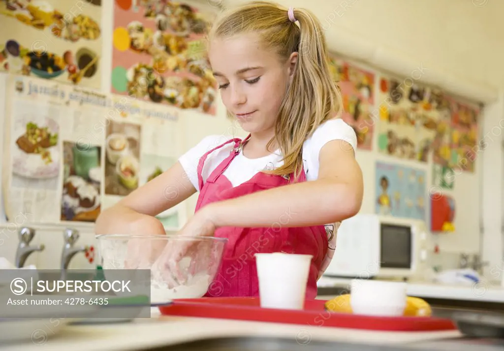 Young girl in cookery class kneading