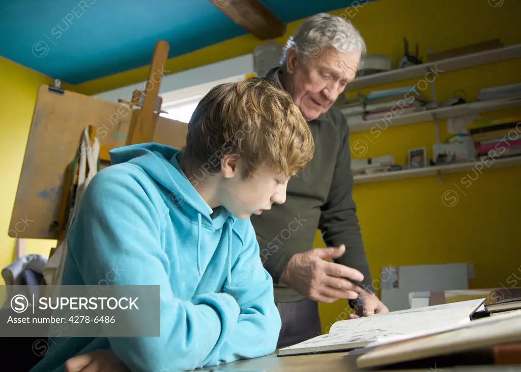 Grandfather showing grandson a drawing book