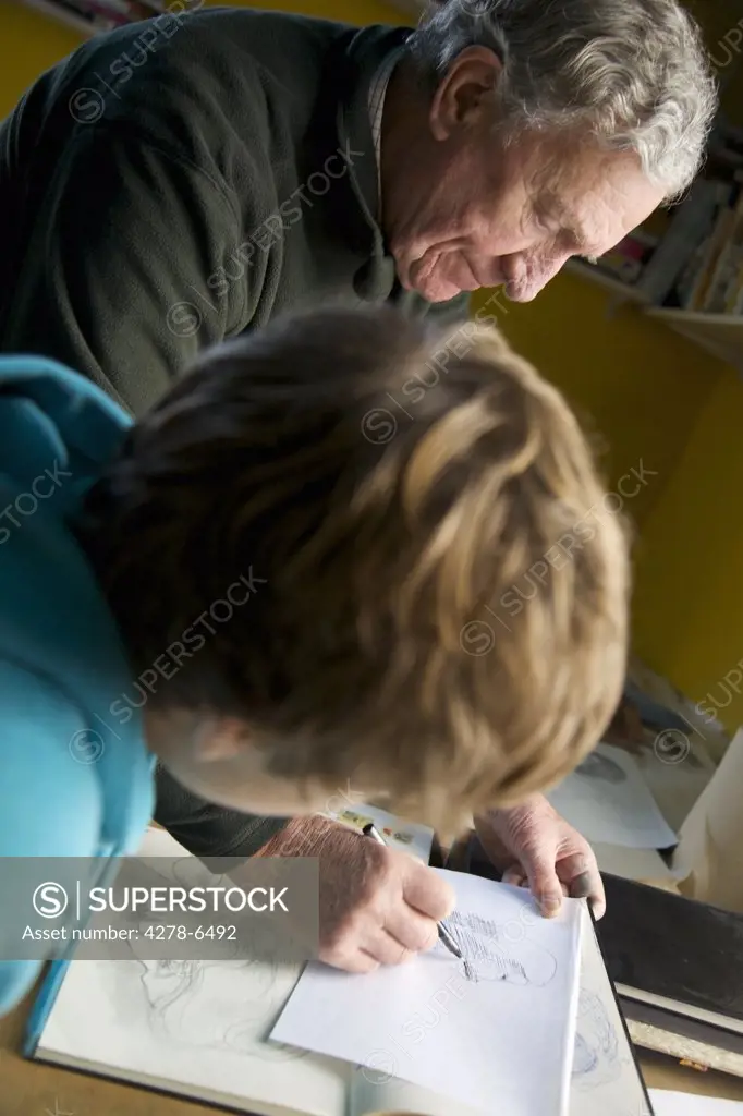 Grandfather teaching grandson to draw
