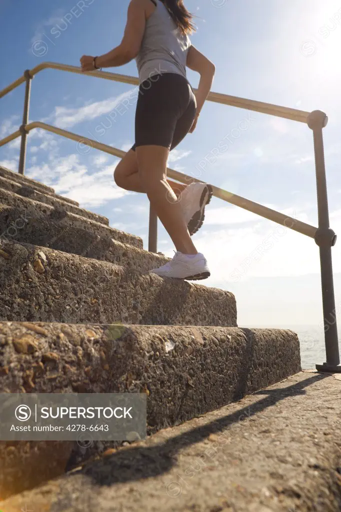 Profile of a woman running up steps, low angle view