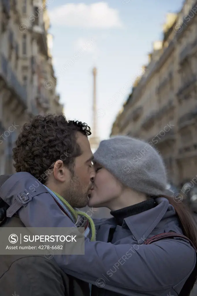 Close up of a couple kissing in a city street