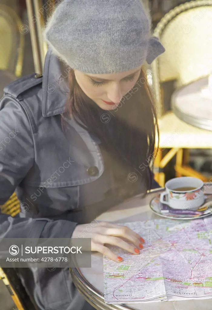 Young woman at cafe looking over a map
