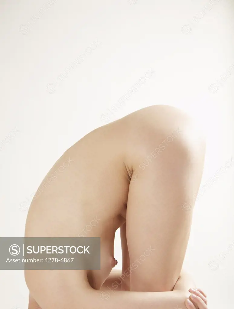 Profile of a nude woman bending over her knees