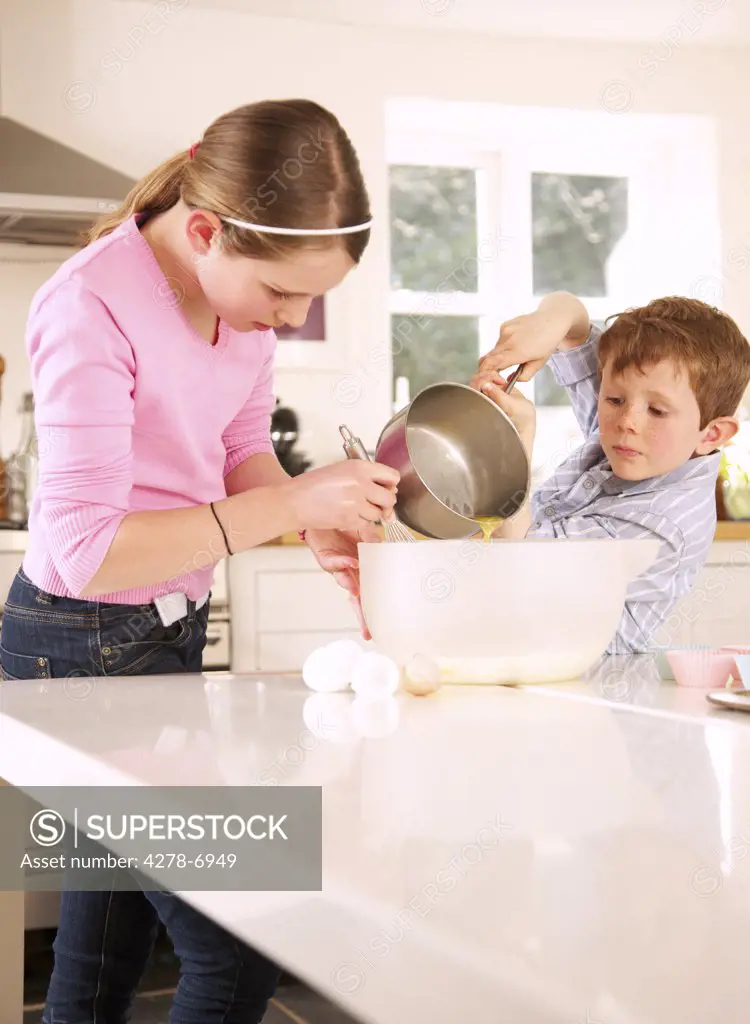Girl and young boy preparing cupcakes