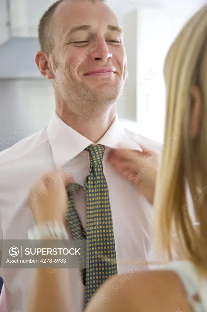 Back View of Woman Tying Man's Necktie