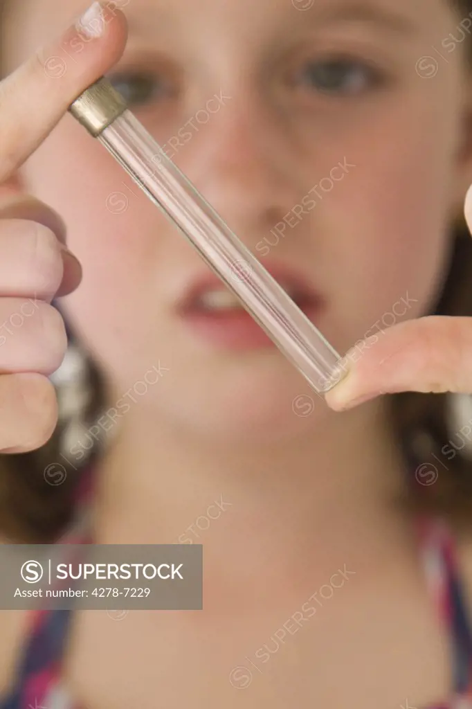 Close up of Girl Holding Test Tube between Fingers
