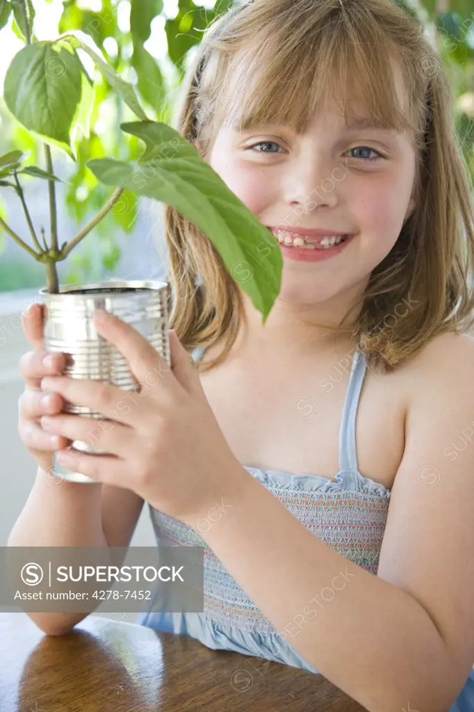 Smiling Girl Holding Plant