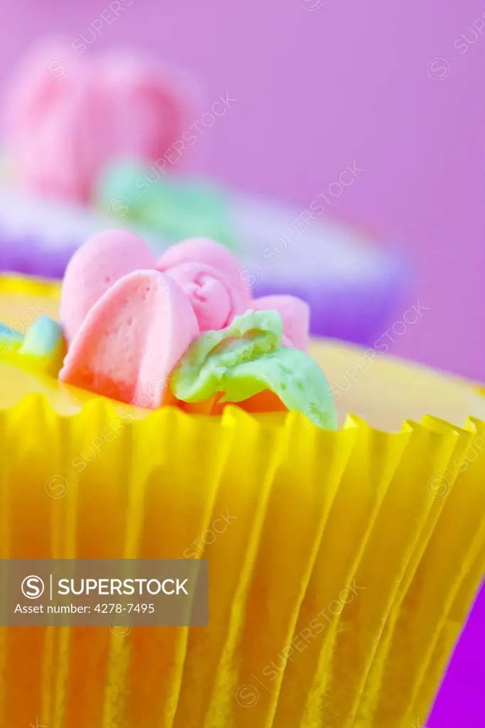 Bright Yellow Cupcake with Pastel Pink Flower Decoration