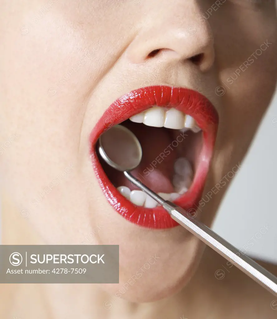 Close up of Woman's Mouth with Red Lipstick during Dental Examination