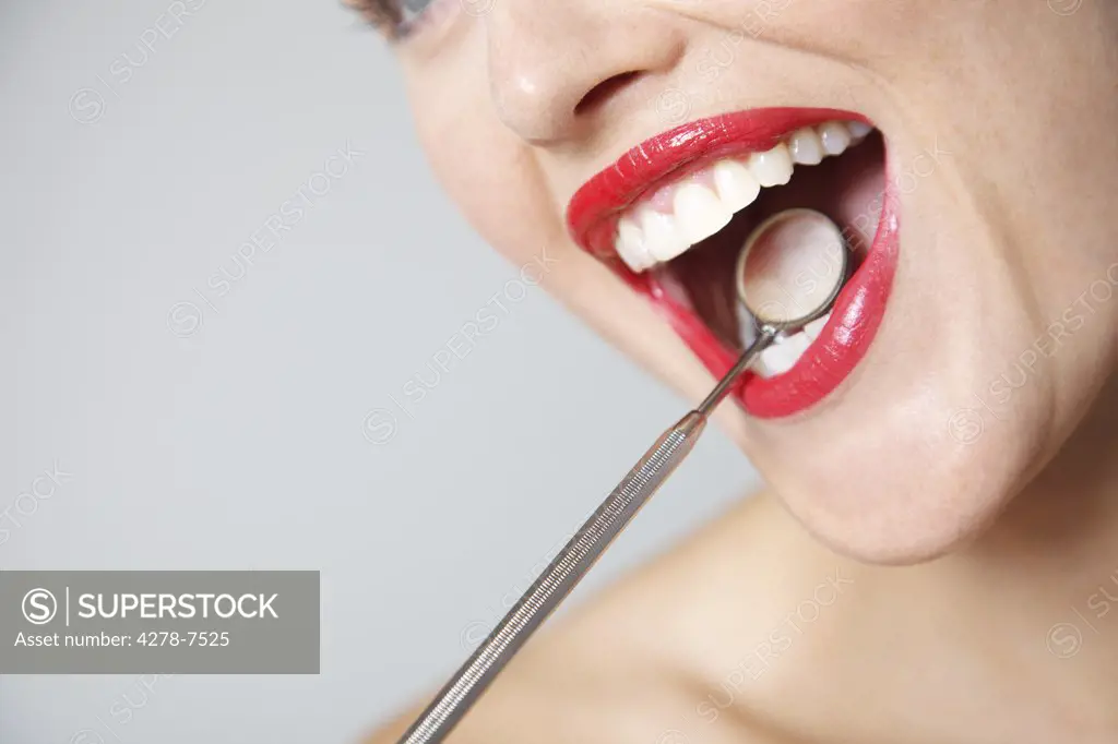 Close up of Woman's Mouth with Red Lipstick during Dental Examination