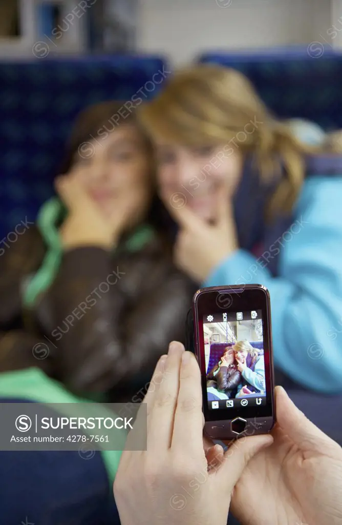 Girl Taking a Photograph of Friends with a Smartphone