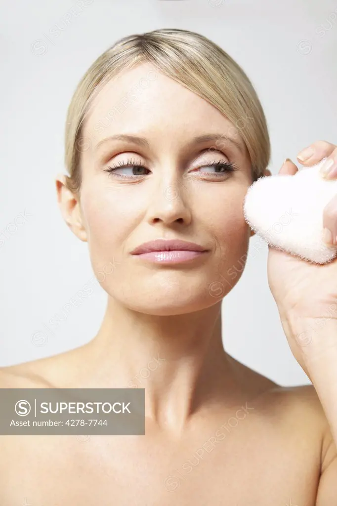 Woman Holding Loofah Sponge next to Face