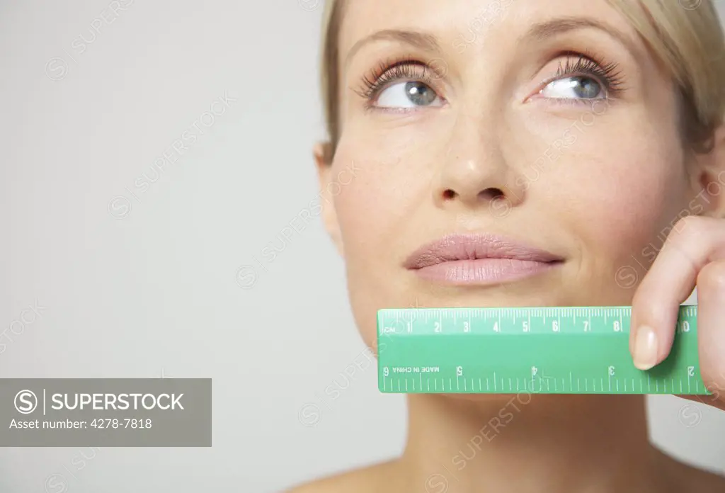 Woman Holding Measuring Ruler under Mouth