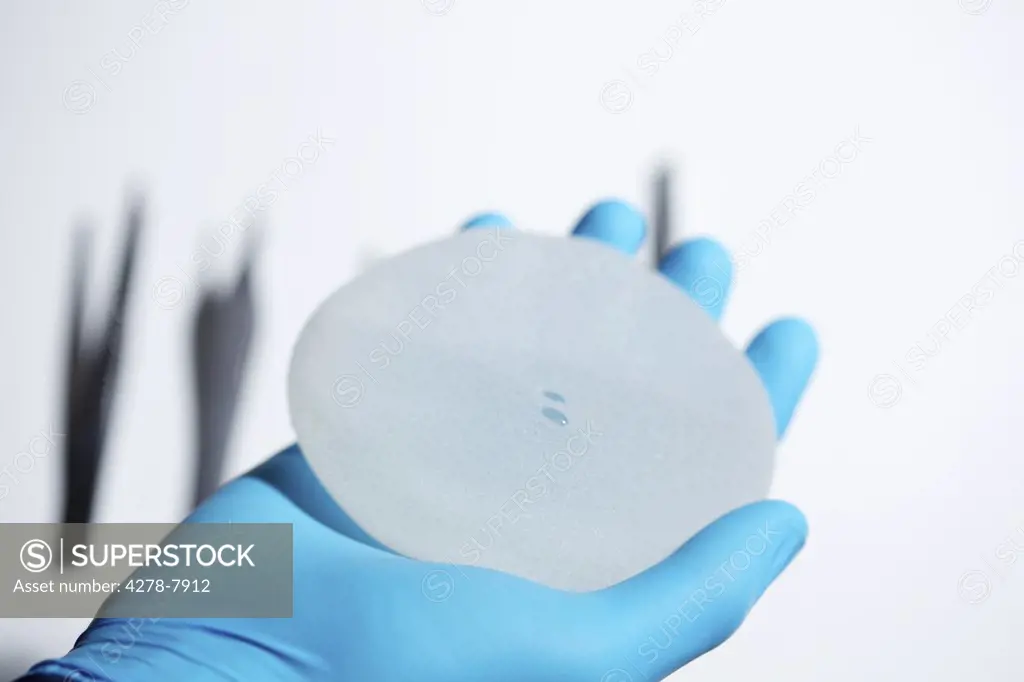 Hand Holding Breast Implant