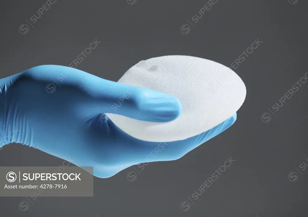 Hand Holding Breast Implant