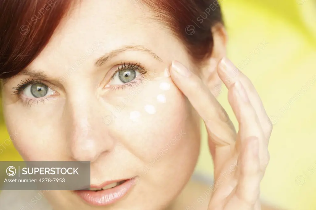 Woman Applying Moisturizing Cream on Face