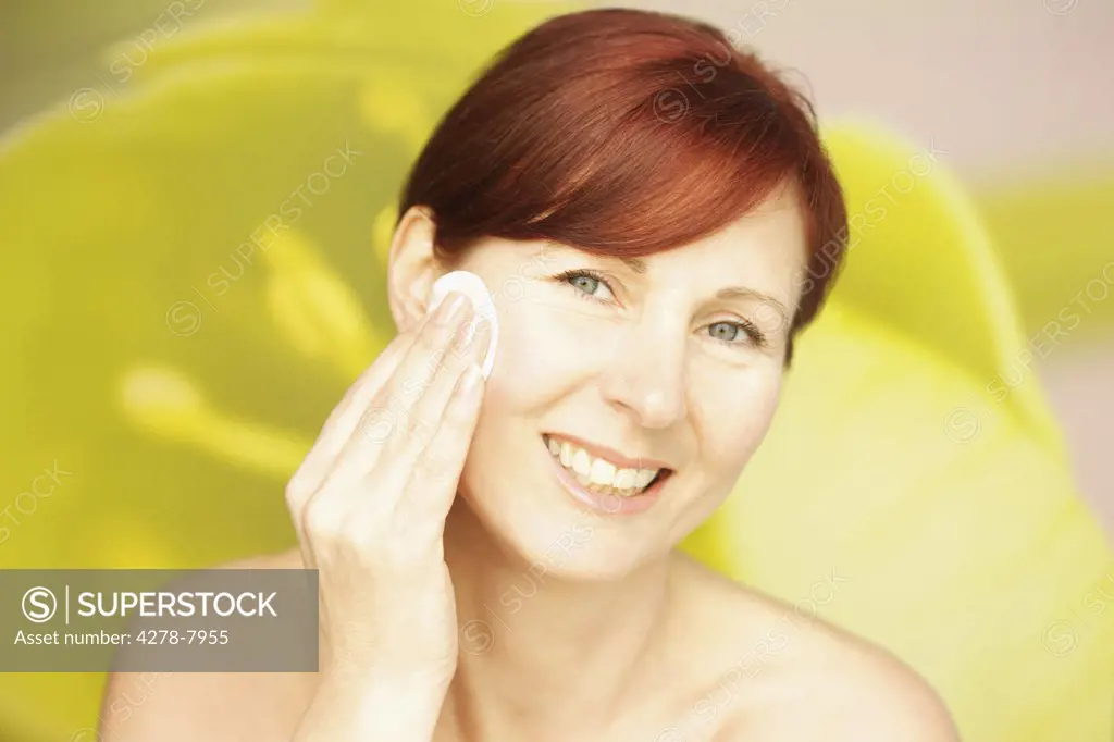 Smiling Woman Using Cotton Pad on Face