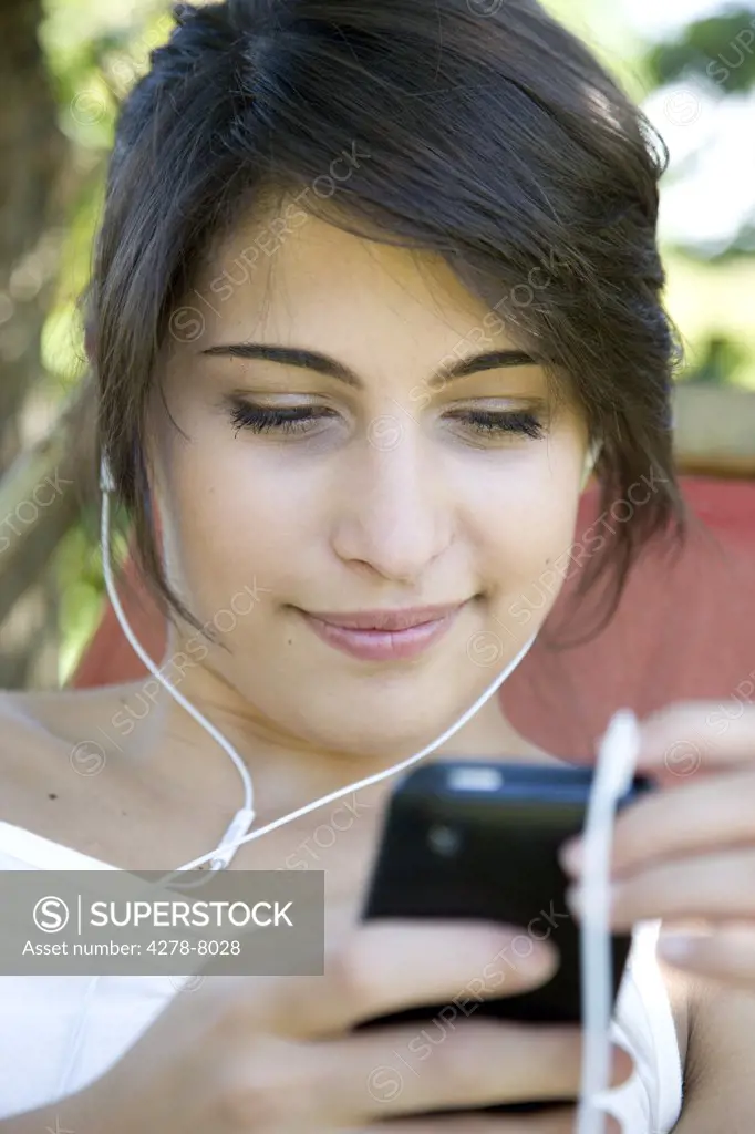 Woman Wearing Headphones Holding Smartphone