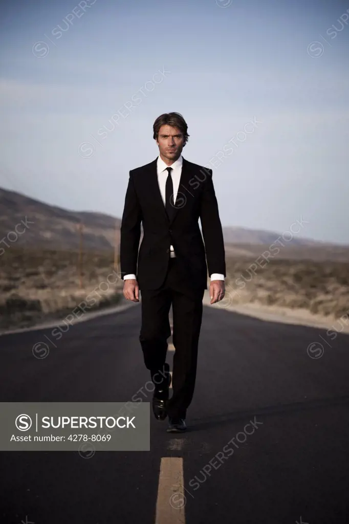 Businessman Walking Down Remote Road