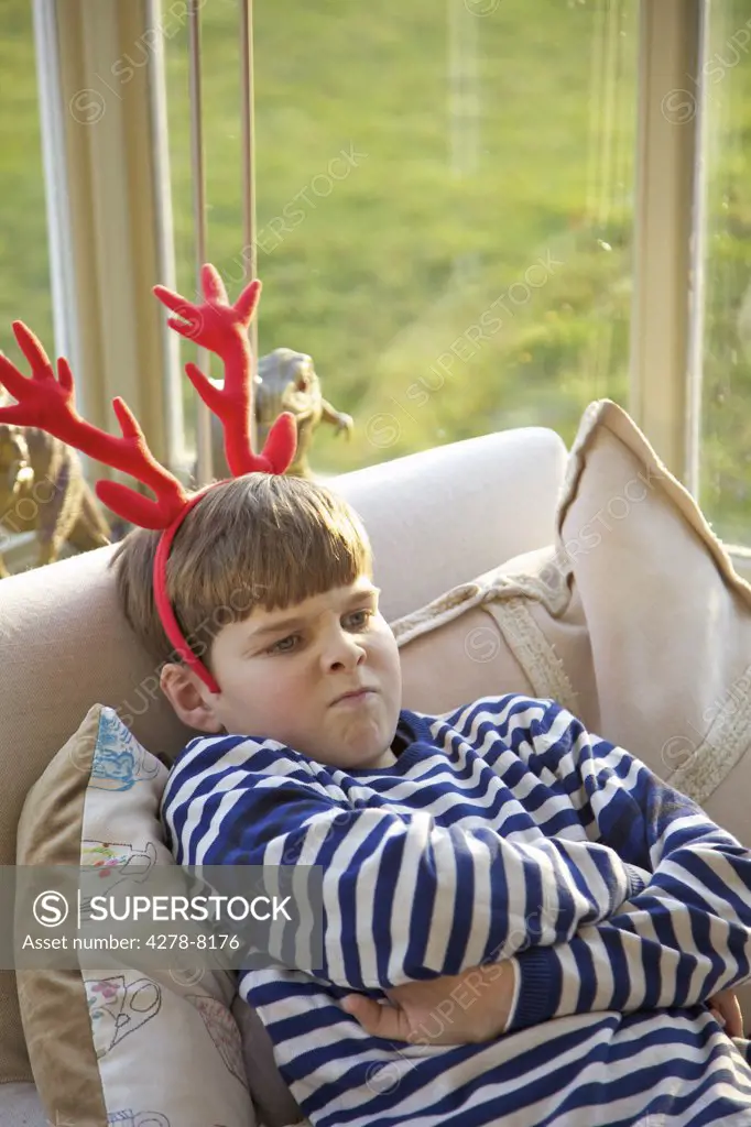 Boy Wearing Christmas Antlers Pulling Faces