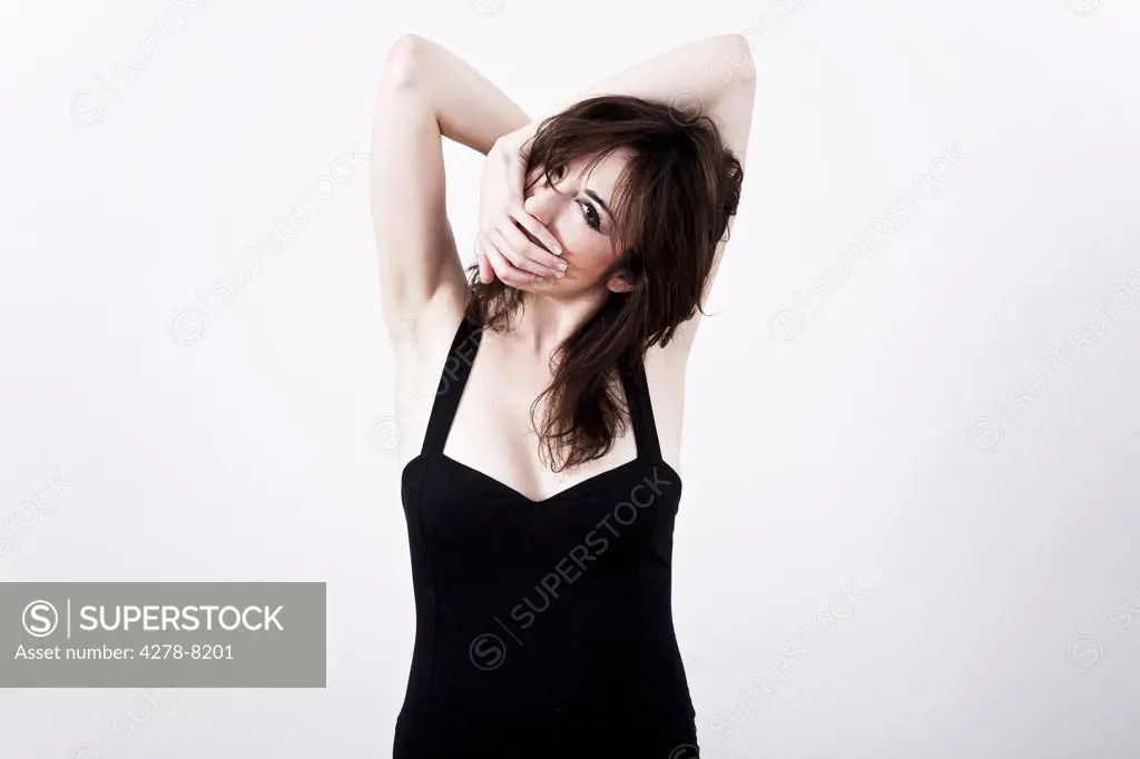 Woman with Arms Behind Head and Hand Covering Mouth