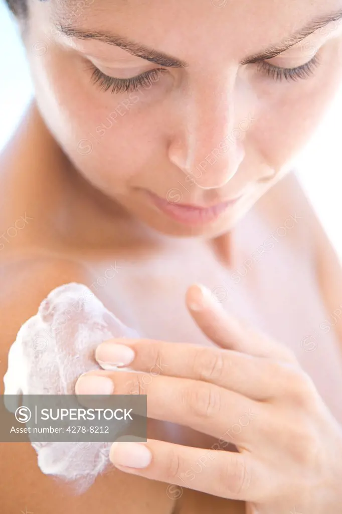 Young Woman Applying Body Lotion on Shoulder