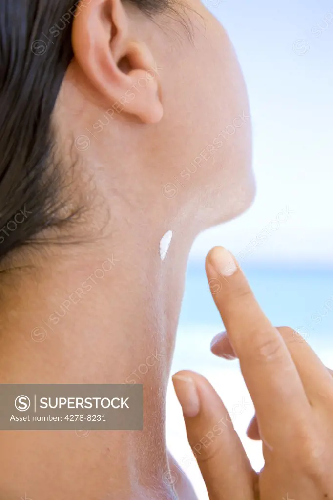 Woman Applying Moisturizer on Neck, Close-up view