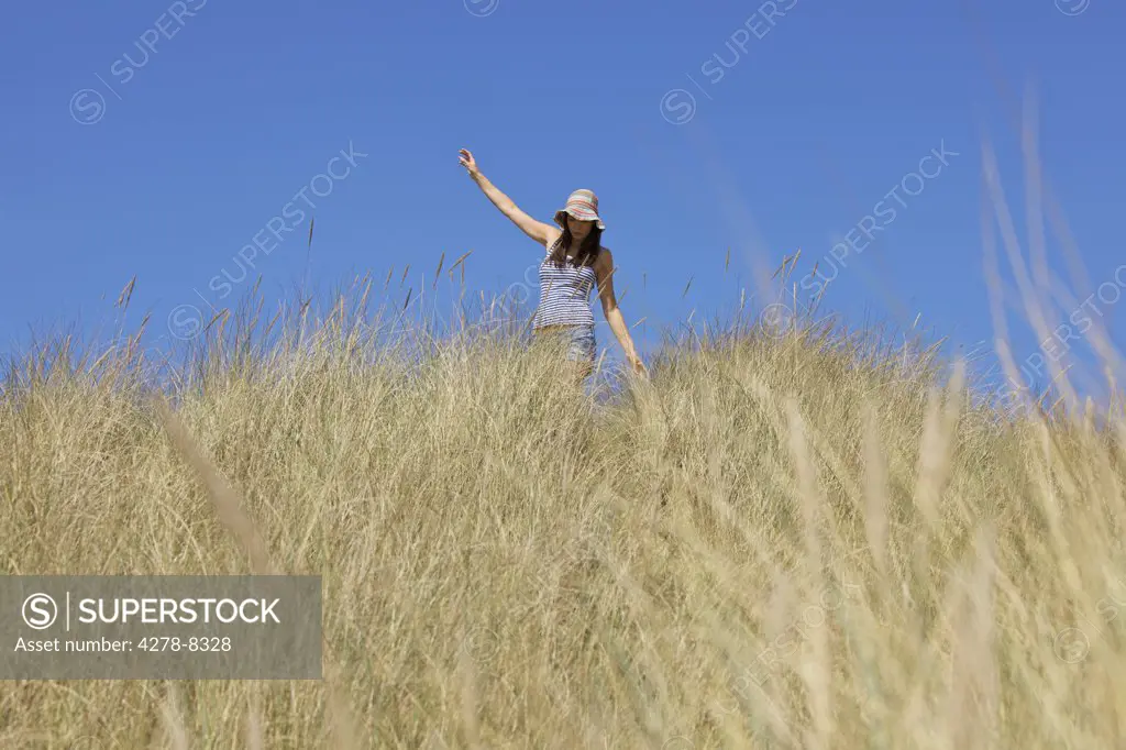 Woman Walking amongst Beach Grass