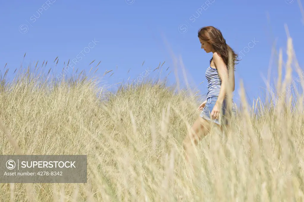 Woman Walking amongst Beach Grass