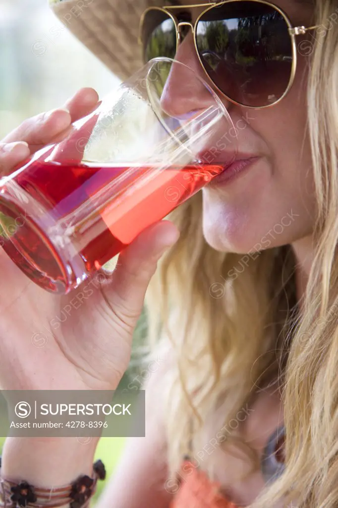 Woman Wearing Aviators Drinking Cranberry Juice