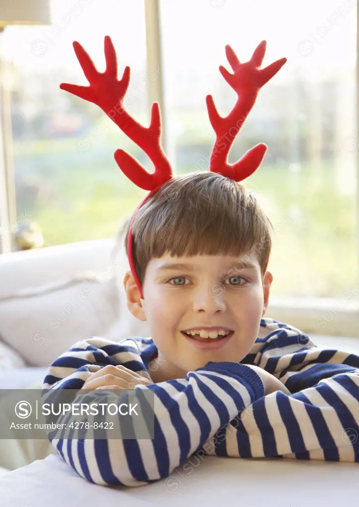 Smiling Boy Wearing Christmas Antlers