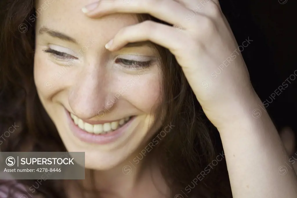 Smiling Young Woman with Hand on Head