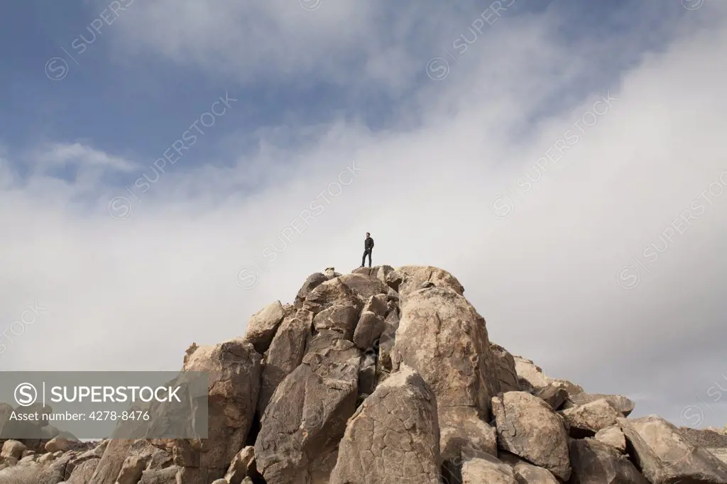 Man Admiring View On Top Of Rock Formation