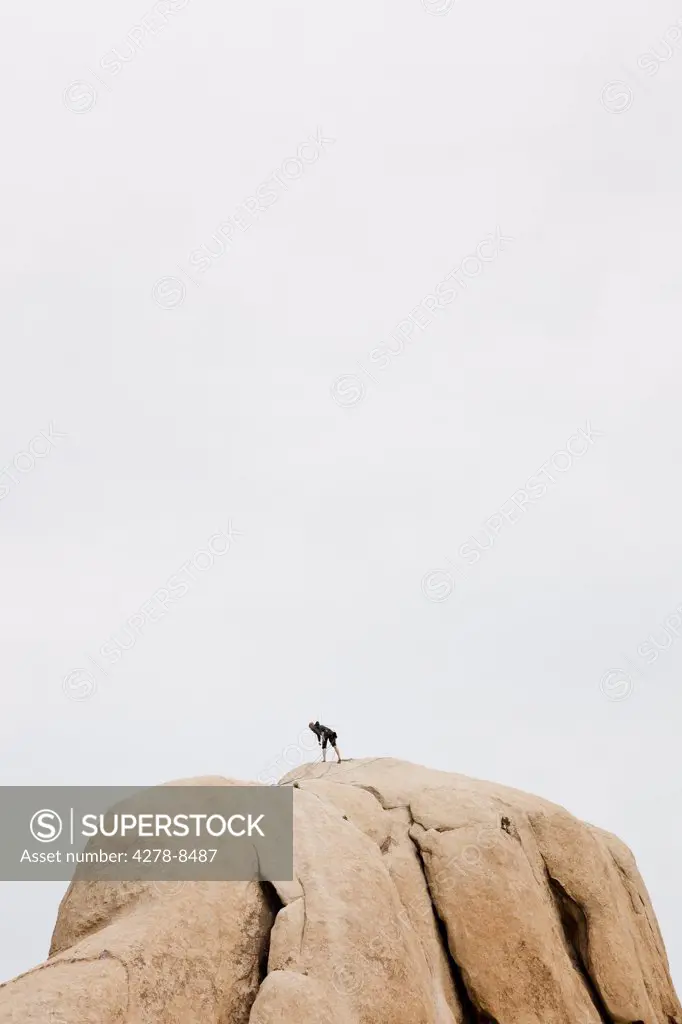 Rock Climber On Top Of Boulder