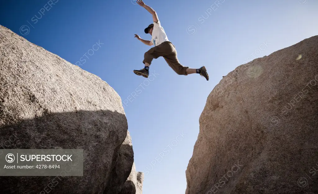Man Leaping between Two Boulders