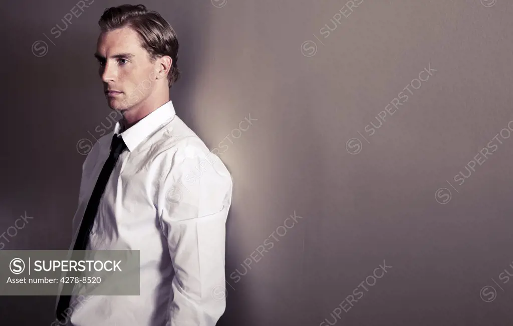 Businessman Leaning against Wall