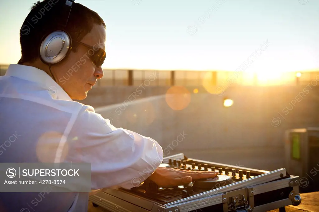 DJ Using Mixing Console at Sunrise