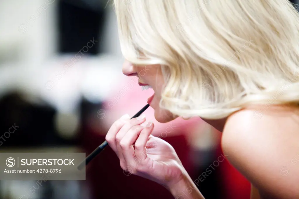 Blonde Woman Applying Lip Liner, Profile