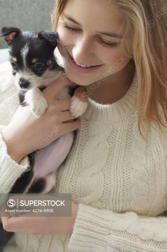 Teenage Girl Hugging Tiny Puppy