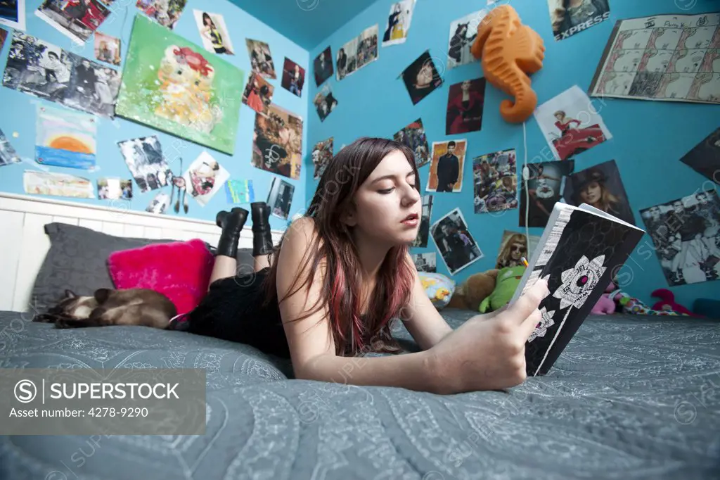 Teenage Girl Lying in Bed Reading