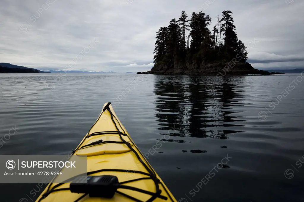 Bow of Yellow Kayak with Walkie-Talkie Moving towards Small Island