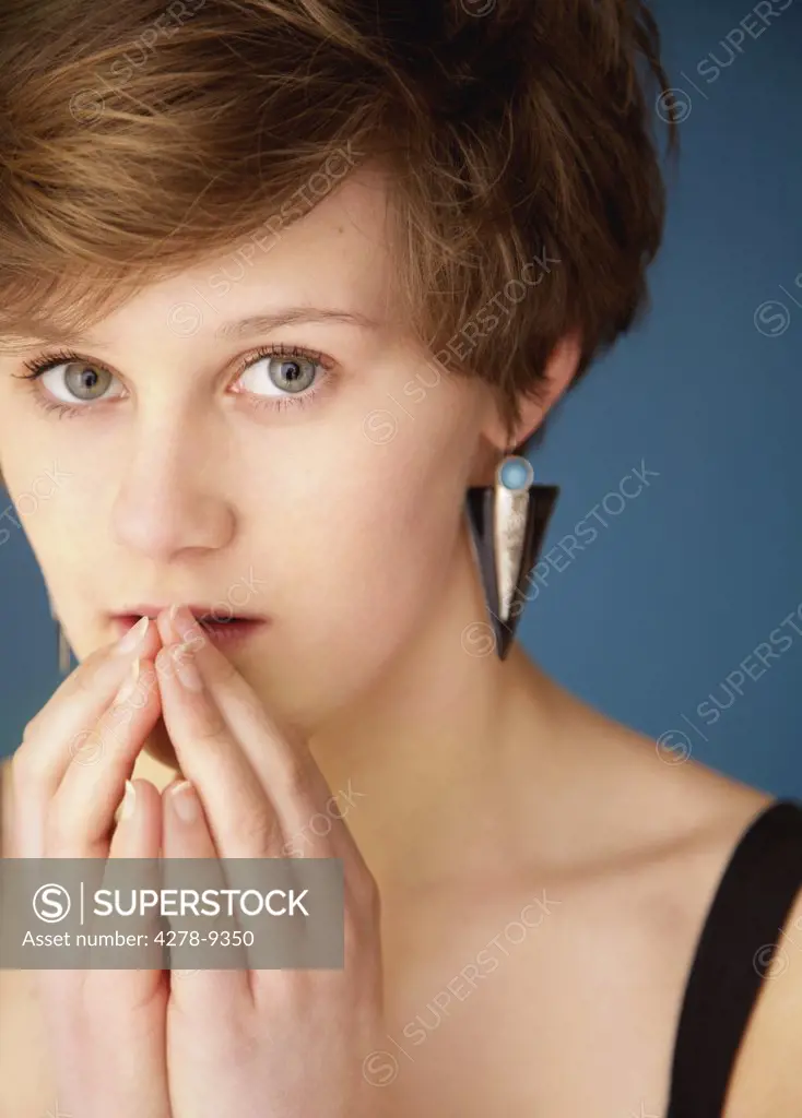 Close up of Teenage Girl with Hands in front of Mouth