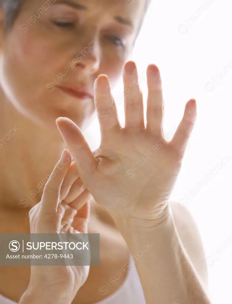 Mature Woman Massaging Hands