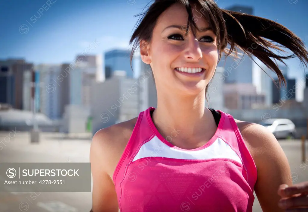 Smiling Young Woman Running Outdoors