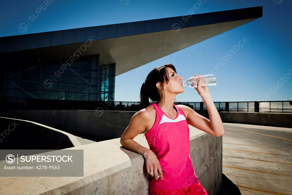 Young Woman in Sportswear Drinking Water
