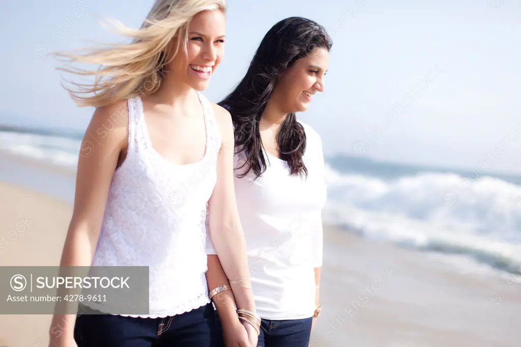 Two Smiling Women Walking on a Beach