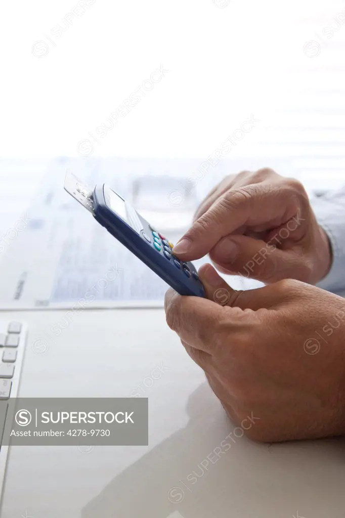 Man's Hands Typing into a Banking Card Reader