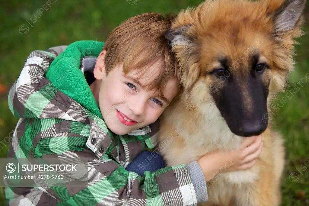 Boy Hugging Alsatian Puppy