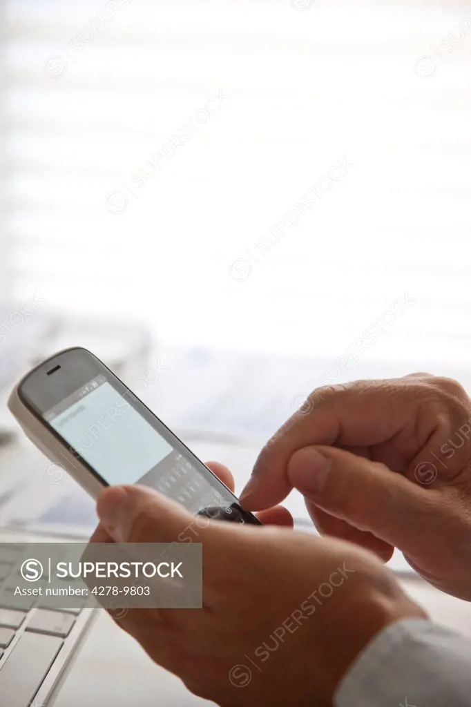 Man's Hands Using Cell Phone