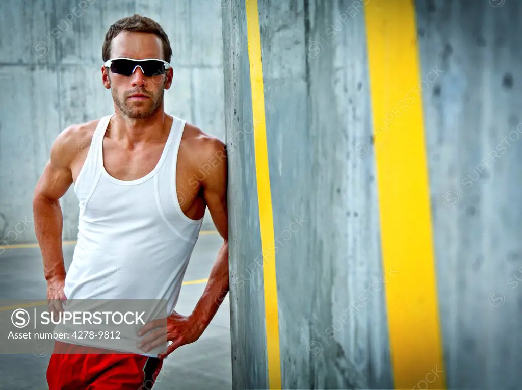 Sportsman Leaning against Concrete Wall